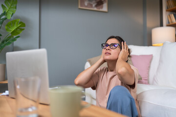 Young nervous sick frustrated woman working at home office on laptop computer, migraine head pain...