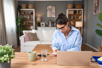 Business woman video call preparation. Young female businessperson prepare herself for online meeting, making notes for internet presentation, thinking and planning for better achievement with client.