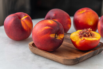 ripe sweet juicy nectarines on a white marble table close up shallow depth of field