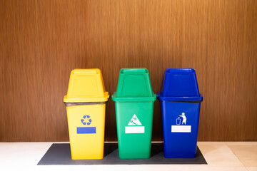 Yellow, green and blue plastic garbage bins separate types of recyclable waste, wet waste, general waste, environmental conservation concept