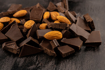 crushed dark chocolate with almonds on a dark background close-up