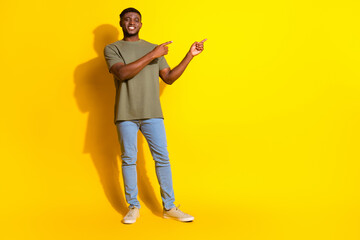 Photo of handsome nice man wear khaki trendy clothes presenting empty space isolated on yellow color background