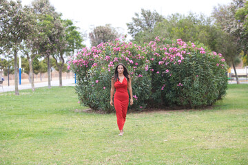young and beautiful Spanish woman with long hair and green eyes dressed in a very elegant red dress...