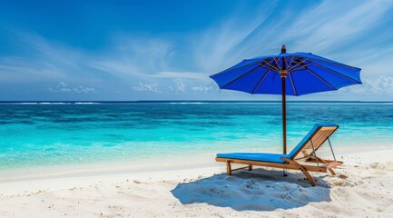 Fototapeta premium A tranquil beach scene featuring a blue umbrella and lounge chair by the turquoise sea.