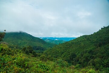 A lush green mountain range with a cloudy sky in the background