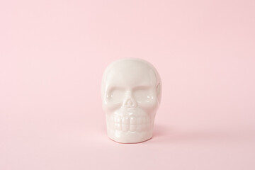 White skull on a pink background. Minimal Halloween spooky concept.