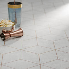 Modern geometric tile flooring with a chic cocktail setup featuring copper bar tools and popcorn in a stylish home interior.

