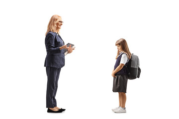 Full length profile shot of a teacher talking to a sad little schoolgirl