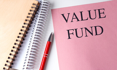 VALUE FUND text on pink paper with notebooks