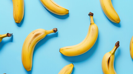  The image shows several yellow bananas arranged on a bright blue background. The bananas are placed randomly, creating an attractive composition