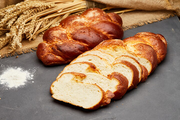 Braided sweet bread loaf sliced, showcasing its golden crust and soft, fluffy interior
