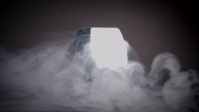 Spinning dice with black background surrounded by smoke 2