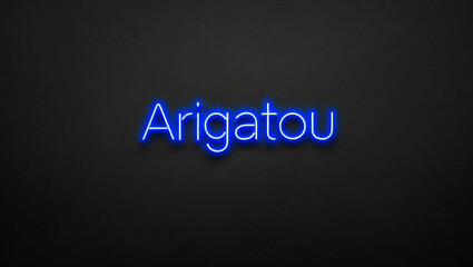 Obraz premium arigatou blue neon lettering on plain dark black background