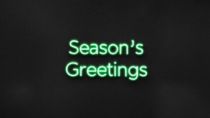 Obraz premium seasons greetings green neon lettering on plain dark black background
