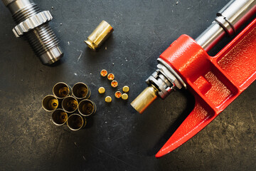 Reloading 45 caliber pistol cartridges, installing primer into cartridge cases.