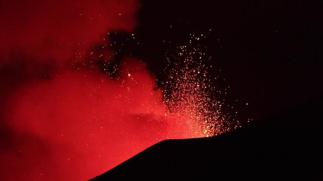 Etna Sicilia - eruzione con esplosioni di lava in dettaglio dal cratere superiore vista di sera