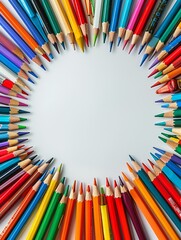 Fototapeta premium Colorful Back to School Frame Background with Pencils and Crayons in Circular Pattern on White