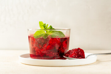 Homemade Raspberry jelly or Confiture, decorated with mint leaves.