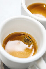 Close-up Vertical Image of Two Steaming Coffee Cups With Gorgeous Crema on Table Top View