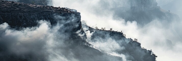 White smoke rising over a cliff, resembling fog or mist, with a towering mountain affected by a wildfire linked to global warming and climate change impacting the environment.