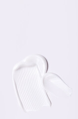 cosmetic smears of creamy texture on gray background