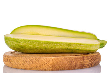 Two halves of ripe zucchini on a wooden tray, macro, isolated on white background.
