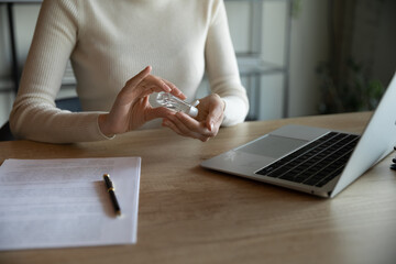 Obraz premium Close up of female employee cleanse hands with sanitizer protect from corona virus pandemic at workplace, woman worker disinfect with antibacterial liquid during covid-19 coronavirus pandemic