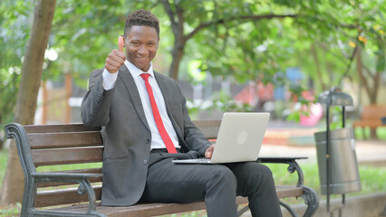 Thumbs Up by African Businessman with Laptop in Lap Outdoor