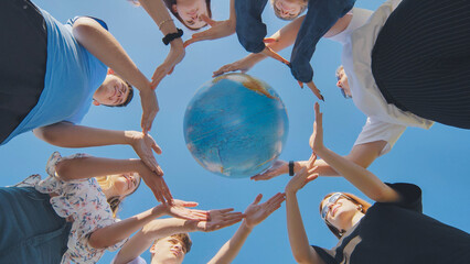 Students make a circle around the globe of the world. The concept of world peace.