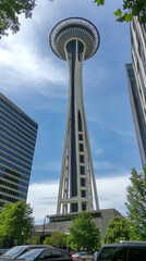 A modern tower piercing the clouds, captured from the base to highlight its full height and grandeur with intricate design and gleaming metal surfaces.