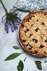 Freshly baked blueberry lattice pie on a table. Beautiful golden crust close up photo. Sweet homemade round cake. Light gray background with space for text. 