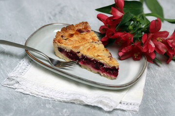 Delicious homemade pie with blueberries and almonds, summer flowers and leaves on light background, top view photo of fresh pastry item 