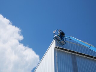 Using a boom truck to work on the roof of a tall building