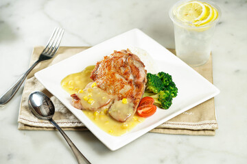 Crispy Chicken Steak with Rice in White Sauce with lemonade, fork and spoon, served in dish isolated on napkin side view of asian food