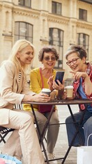 A group of friends relishing their coffee while sharing laughter joyfully outdoors in the sun