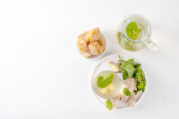Sweet Ginger Mint Coconut Water Cooler with honey, infused ginger mojito cocktail on white table background copy space