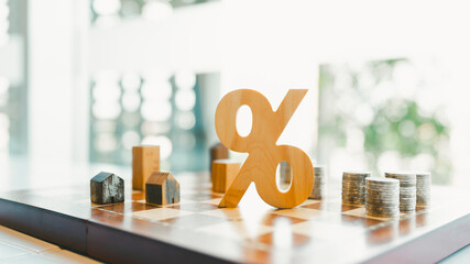 Percentage and house model with pile of money on chessboard is an idea about tax management...