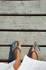 women's legs in a slate bridge made of white wooden planks. summer vacation. background for the...