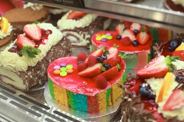 A tempting display of freshly baked buns and cream cakes. Soft, golden buns and colorful cream cakes with intricate decorations are artfully arranged on rustic shelves, showcasing their delicious appe