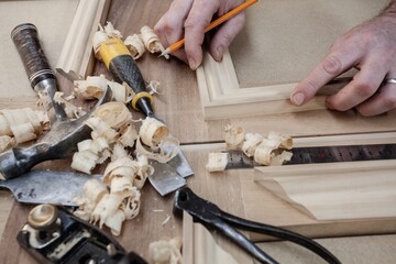Bespoke joinery showing the carpenter doing all the tasks using the tools like hammer, chisel, drill, steel ruler, glue gun and pencil