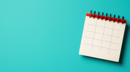 Blank desk calendar with red binder on teal background, perfect for planning, organization, and time management visuals.