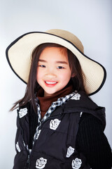 Asian little girl wearing a straw hat on white background