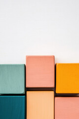 Fototapeta premium Colorful wooden blocks arranged against a clean white background, creating a minimalist geometric pattern, perfect for design and creative projects.