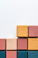 Fototapeta premium Colorful wooden blocks arranged in a minimalist pattern against a white background. Ideal for concepts of organization, creativity, and simplicity.
