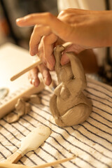 Wooden Tool Refining Clay Sculpture in Pottery Workshop