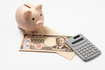 日本円の新紙幣の一万円札と豚の貯金箱と電卓 © 洋 奥山
