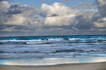 Scenic view of a dramatic ocean scene with crashing waves under a cloudy sky,