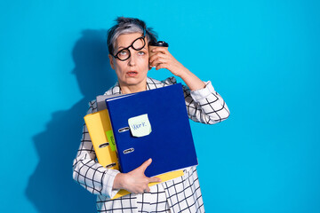 Photo of tired senior woman wear stylish clothes drink latte work hard isolated on blue color...
