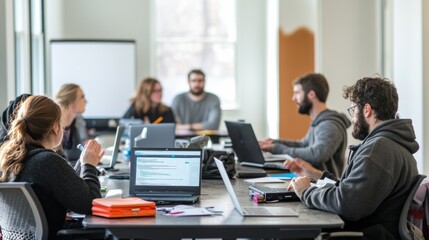 A group of people engaged in a collaborative meeting, working on laptops and discussing ideas in a bright, modern office space.