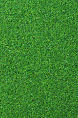 Fototapeta premium Artificial green grass mat, top view. Texture. Artificial turf, surface made of synthetic fibers. Flat green grass texture background. Short artificial grass golf surface